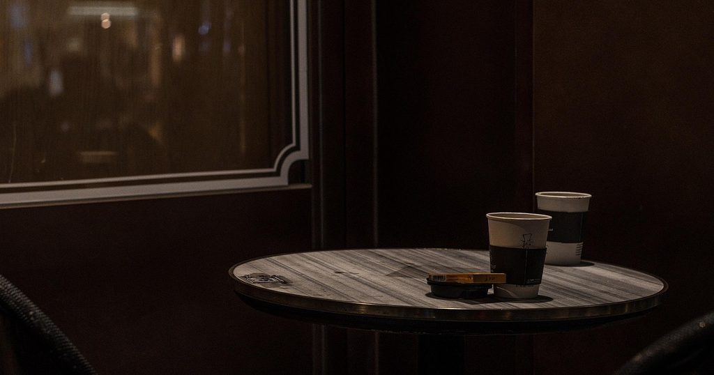 落ち着いた店内の丸いテーブルに置かれた紙コップのコーヒー
